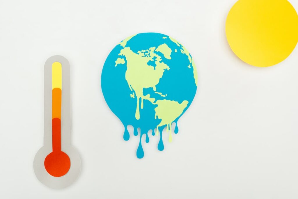 Kleurenillustratie van wereldkaart, thermometer en zon.