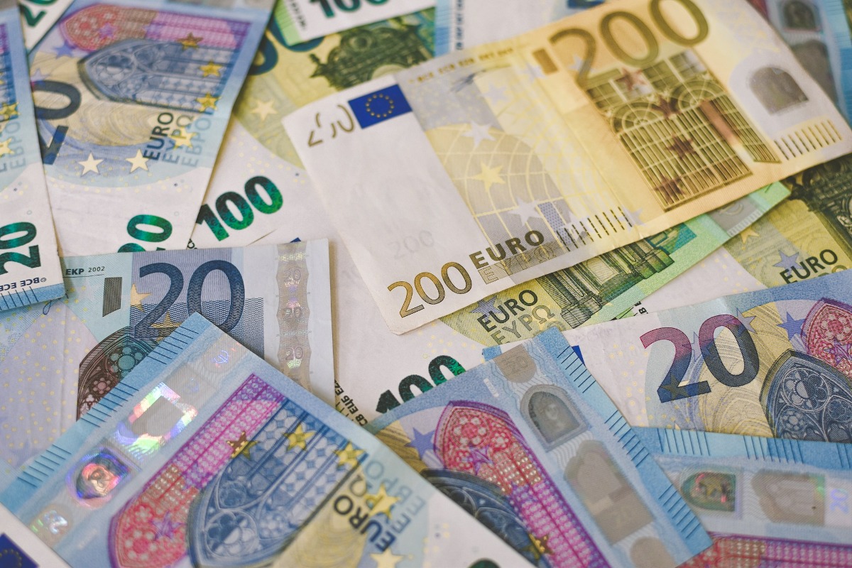 Losse eurobiljetten in verschillende waardes liggen verspreid op een tafel.