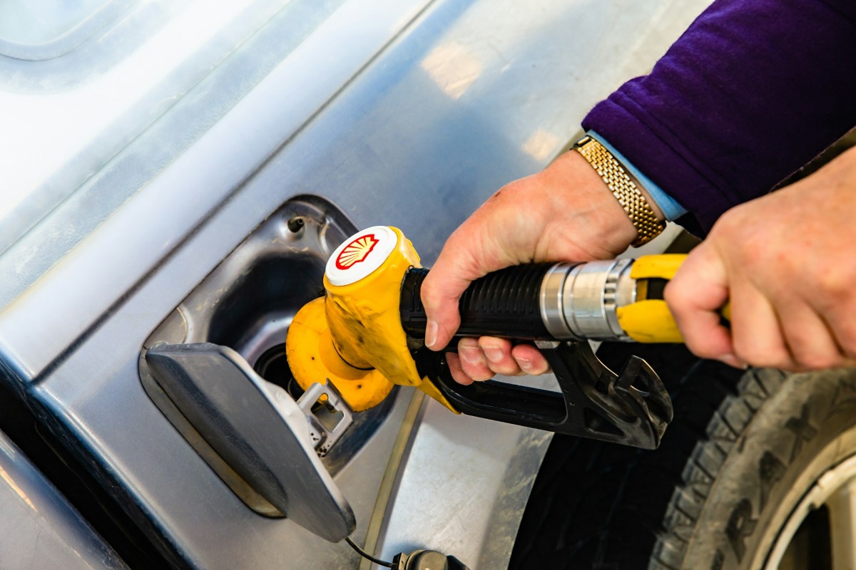 Automobilist vult de brandstoftank bij een pomp op het tankstation